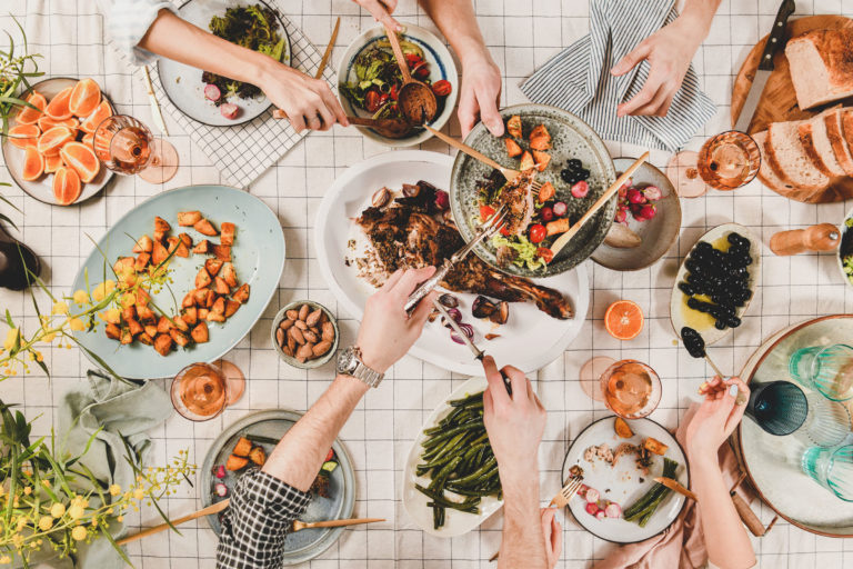Peoples hands with various snacks and blooming mimosa, top view Peoples hands with various snacks and blooming mimosa, top view