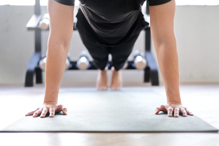 Asian woman doing push-ups in a training gym